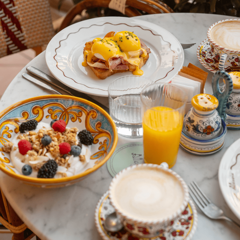delicious-breakfast-spread-with-different-options-such-as-eggs-benedixt-museli-with-yoghurt-and-glasses-of-orange-juice